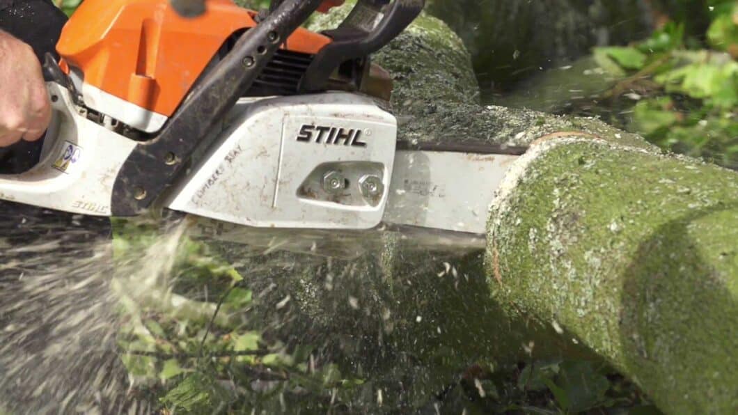 Stihl chainsaw being used to cut a branch